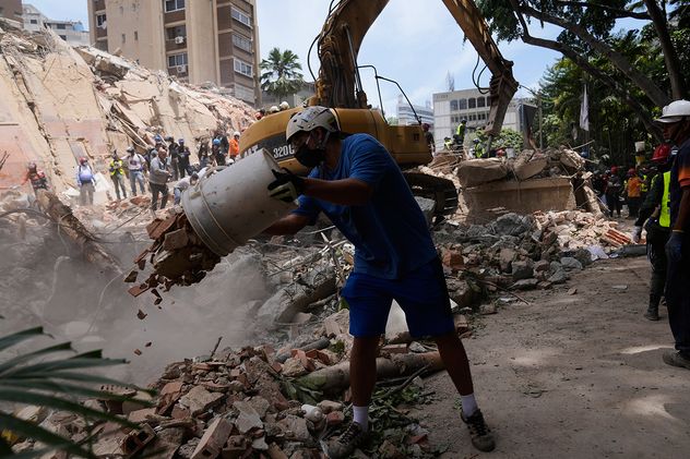 Residentes y rescatistas buscan entre los escombros de un edificio que se derrumbó en los terremotos que sacudieron el día anterior en Caracas, Venezuela, jueves 25 de junio de 2026. 