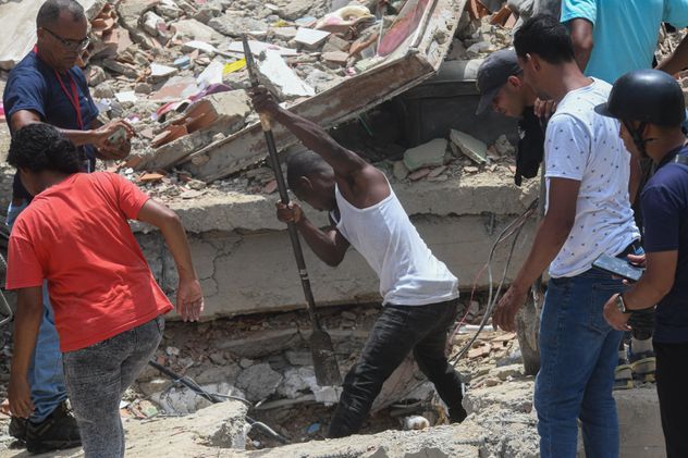 Personas remueven escombros de un edificio derrumbado en busca de sobrevivientes luego de que se registraran dos terremotos, en Playa Grande, estado La Guaira, Venezuela.