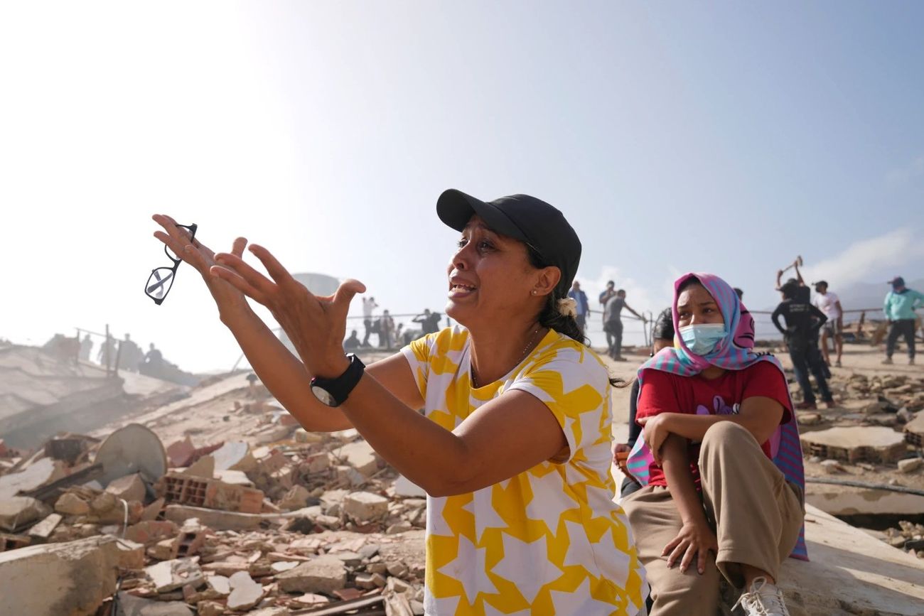 Personas buscan familiares desaparecidos en el edificio derrumbado donde vivían dos días después de que un terremoto azotara La Guaira, Venezuela, el 26 de junio de 2026. (Ariana Cubillos)
