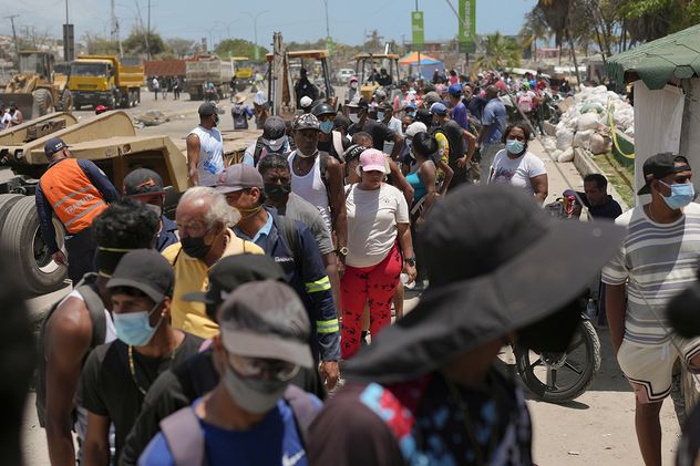 Personas afectadas por los terremotos hacen fila para recibir alimentos distribuidos por el gobierno en La Guaira, Venezuela.