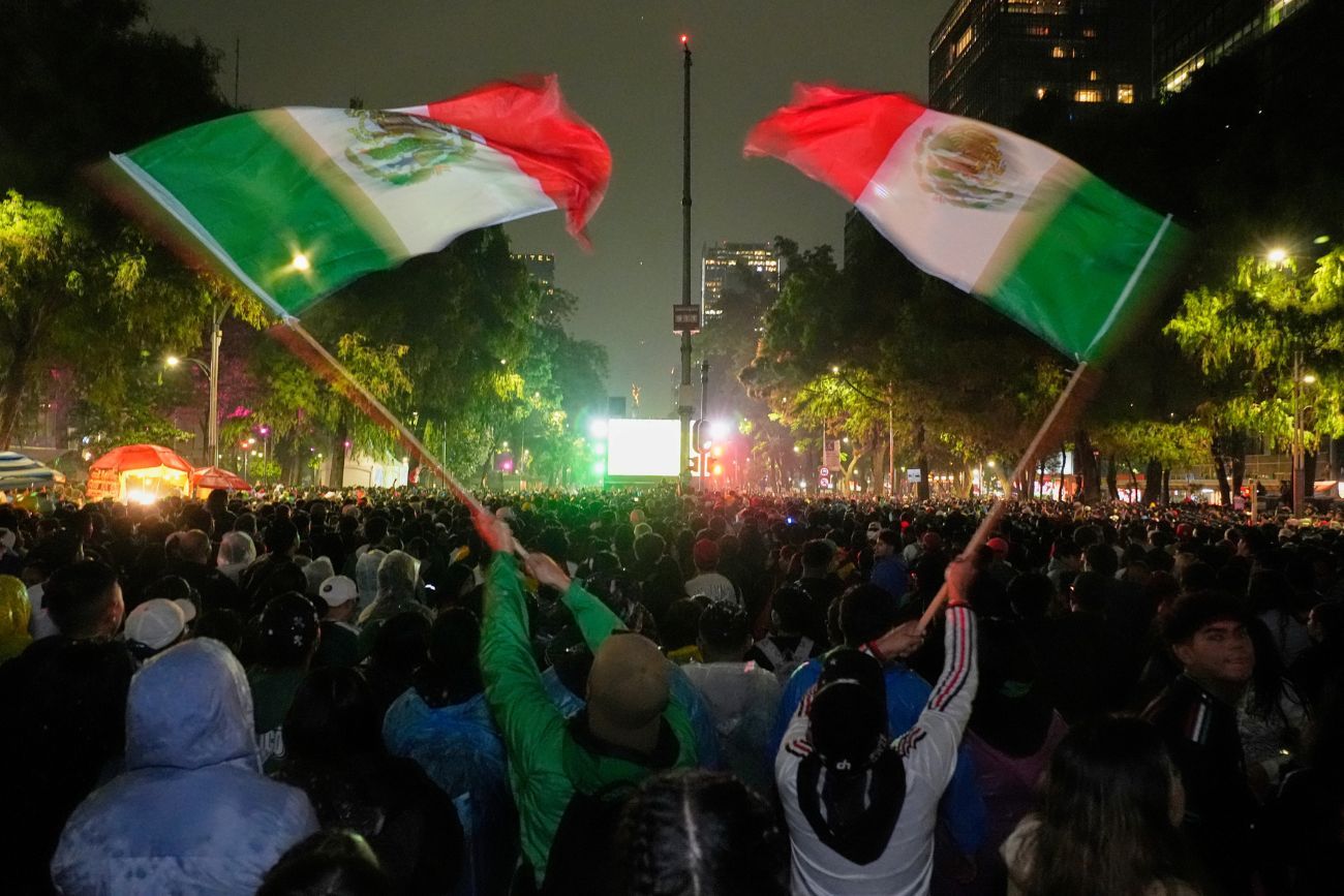 Aficionados mexicanos ondean banderas mientras observan el partido de dieciseisavos de final del Mundial entre México y Ecuador cerca del Ángel de la Independencia en la Ciudad de México, el martes 30 de junio de 2026. 