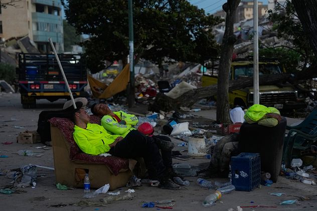Grupos de rescatistas buscan entre los escombros de un edificio que se derrumbó en los terremotos ocurridos en La Guaira, Venezuela.