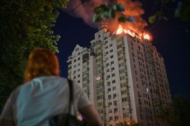 Una mujer observa un edificio de apartamentos en llamas tras un ataque con misiles rusos en Kiev, Ucrania, el jueves 2 de julio de 2026.