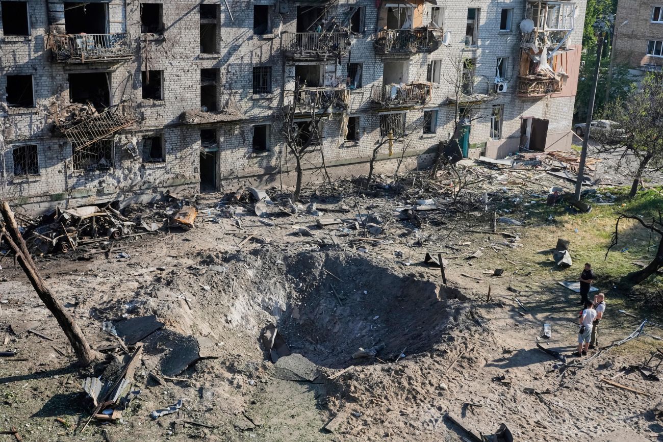 Personas observan el lugar donde impactó un misil ruso contra un edificio residencial en Kiev, Ucrania, el jueves 2 de julio de 2026. (AP / Efrem Lukatsky)