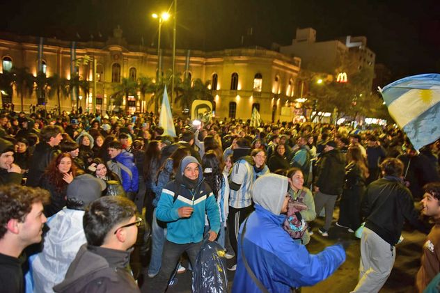 Hinchas festejan la victoria de Argentina ante Cabo Verde frente al Patio Olmos, en el centro de Córdoba.