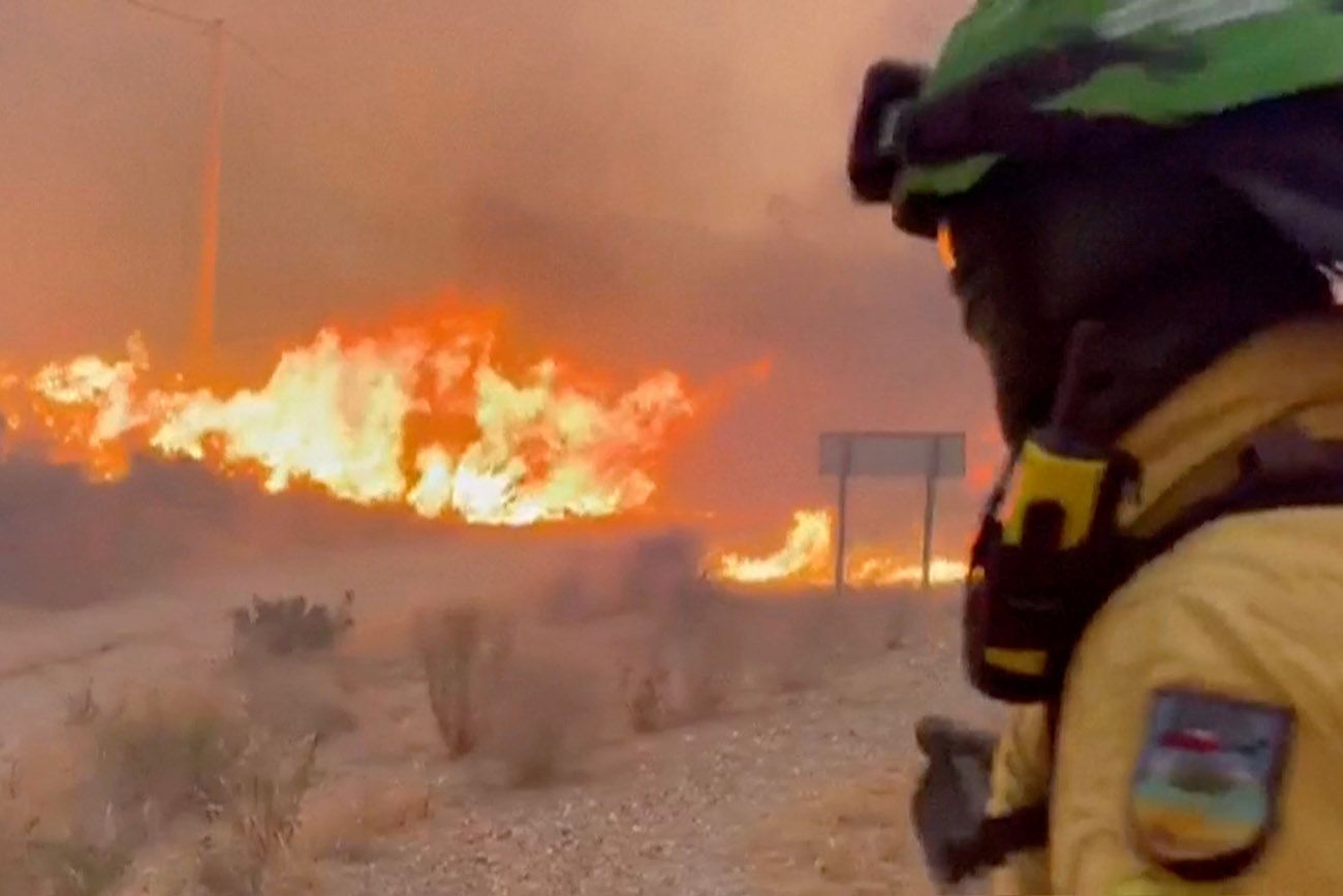 Unidad Militar de Emergencias, muestra a miembros de dicha unidad española rociando agua sobre vegetación en llamas durante un incendio forestal cerca de Los Gallardos, Almería (España), el viernes 10 de julio de 2026. 