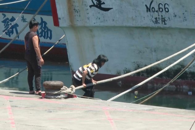 En esta imagen extraída de un video, se ve a hombres asegurando embarcaciones en el puerto pesquero de Shen'ao ante la llegada del tifón Bavi, frente a la costa de la ciudad de Nuevo Taipéi, Taiwán, el jueves 9 de julio de 2026. (Foto AP/Taijing Wu)