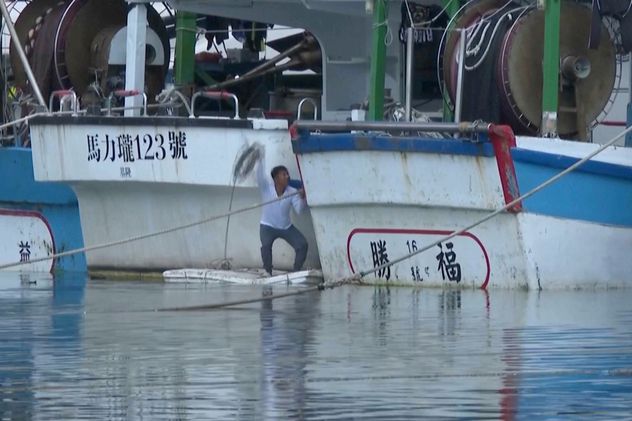 En esta imagen extraída de un video, se ve a hombres asegurando embarcaciones en el puerto pesquero de Shen'ao ante la llegada del tifón Bavi, frente a la costa de la ciudad de Nuevo Taipéi, Taiwán, el jueves 9 de julio de 2026. (Foto AP/Taijing Wu)