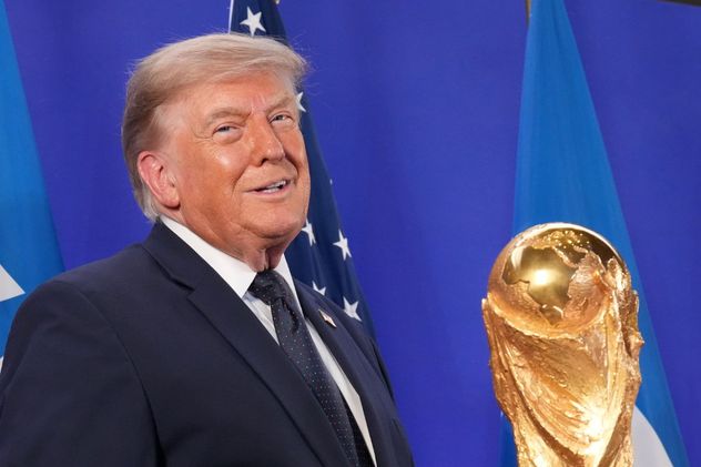Donald Trump junto a la Copa del Mundo en una conferencia de prensa.