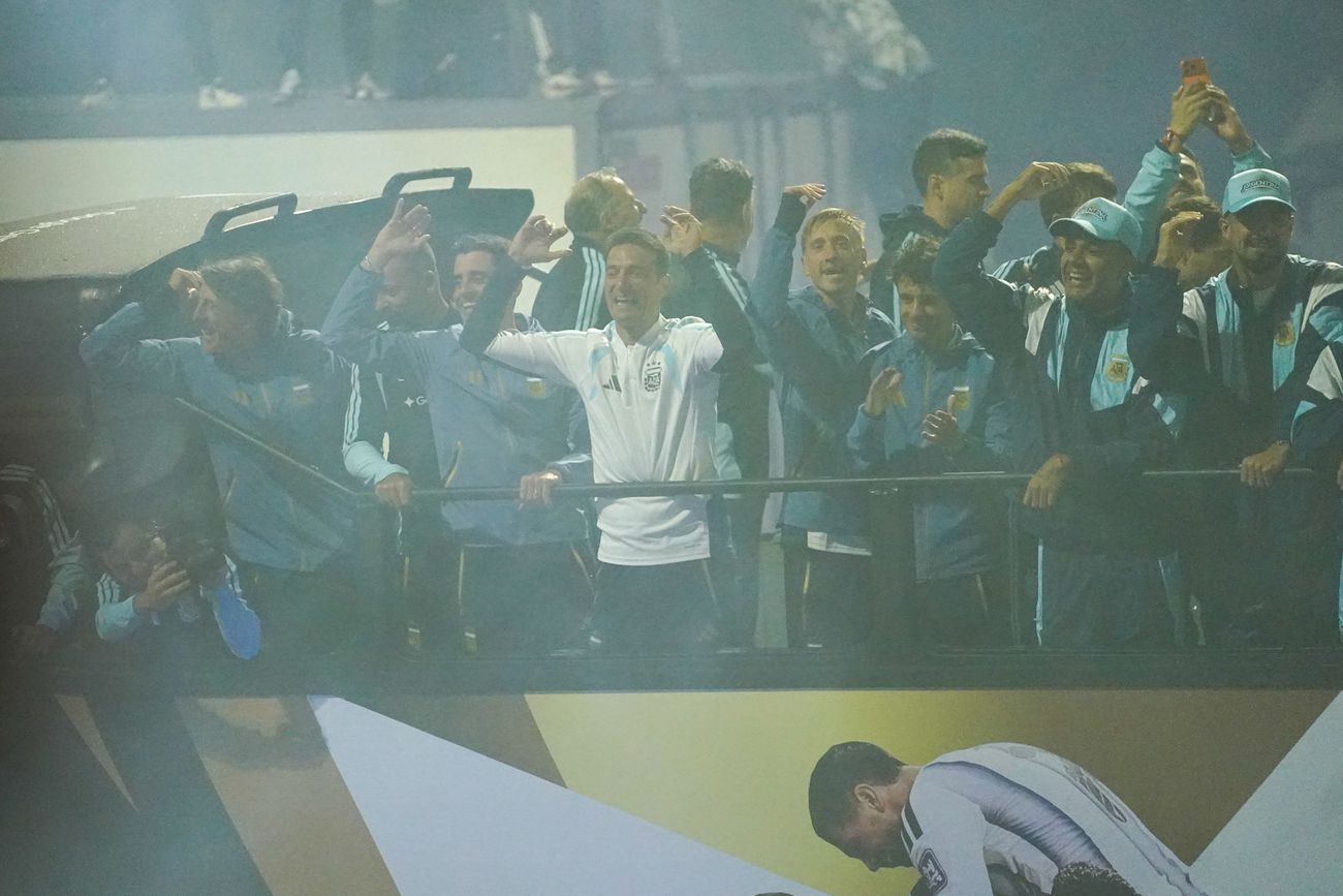 Los jugadores de la selección y el entrenador Lionel Scaloni saludan a los hinchas desde el colectivo en su regreso al país. (Gentileza Clarín)