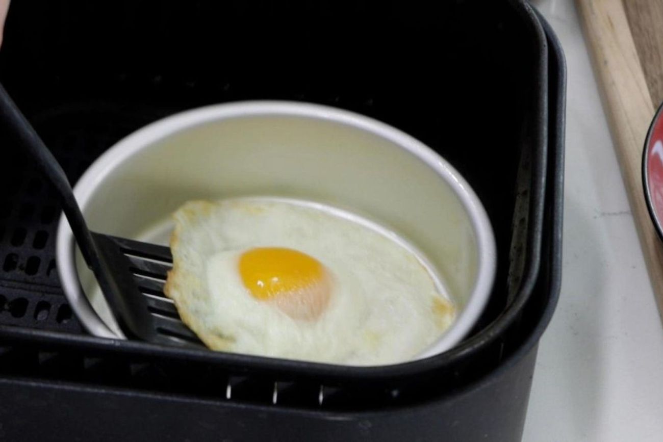 Con un pequeño recipiente apto para altas temperaturas y unas gotas de aceite, la freidora de aire permite preparar un huevo frito de forma práctica y con menos grasa.