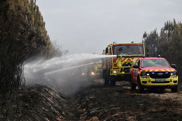 Bomberos combaten un incendio forestal que arrasa las cercanías de Le Las, en las afueras de Burdeos, Francia.