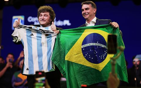 El senador brasileño Flavio Bolsonaro sostiene una bandera de Brasil mientras el presidente argentino Javier Milei hace lo propio con una camiseta de la selección argentina de fútbol, durante la convención del Partido Liberal, en la que se confirmó a Bolsonaro para que sea el candidato presidencial del partido.