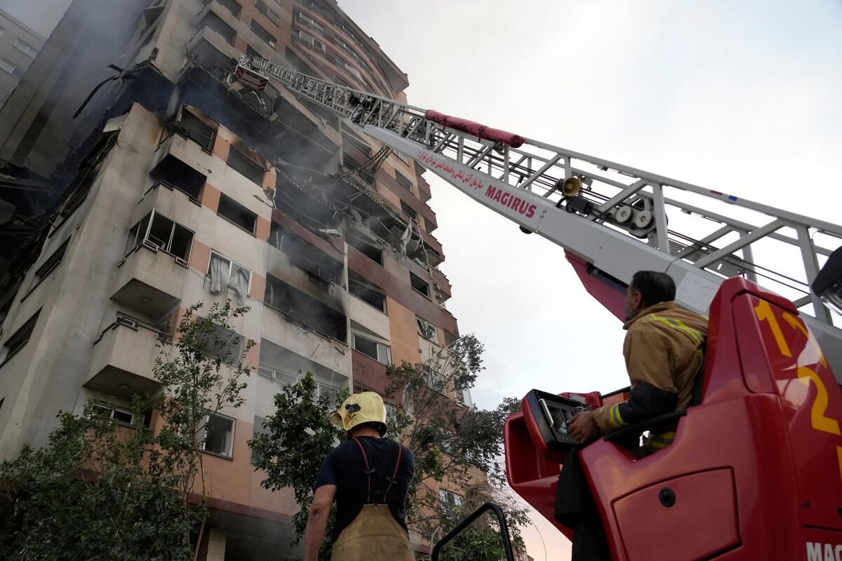 Un grupo de bomberos trabaja en el sitio de una explosión en un complejo residencial en el norte de Teherán, Irán, el viernes 13 de junio de 2025. (AP Foto/Vahid Salemi)