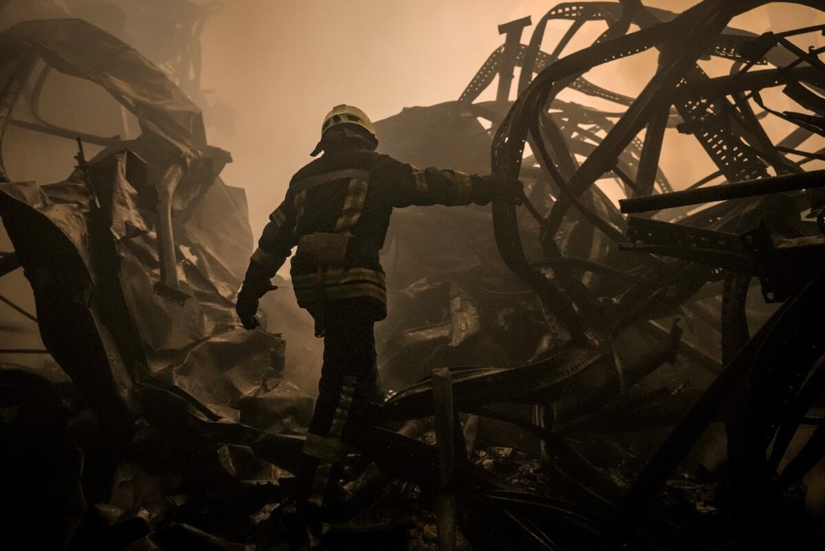Un bombero ucraniano camina por los restos destruidos de un galpón de productos alimenticios que fue destruido por por los bombardeos rusos cerca de Kiev. (AP Photo / Vadim Ghirda)