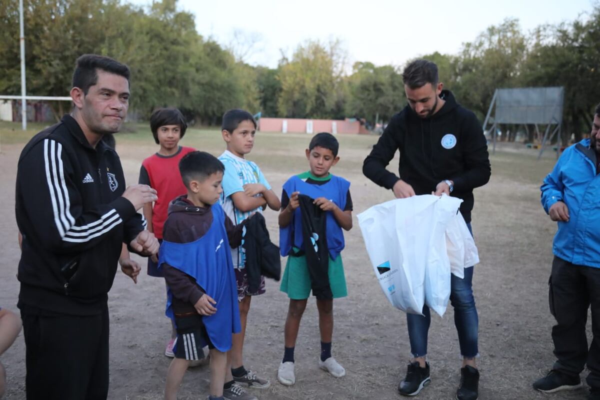 Futbolistas de Belgrano en la Escuelita Atletic de Barrio Argüello, donde se entregaron kits deportivos con pelotas, conos y pecheras. (Prensa Belgrano)