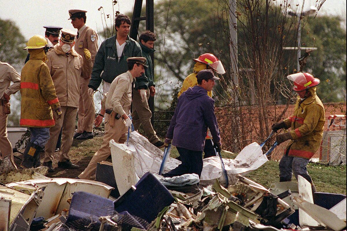 25 años de la tragedia de Lapa. Bomberos llevan una bolsa con un cuerpo rescatado del avión argentino que se estrelló el martes con al menos 69 personas a bordo. (Archivo / AP)