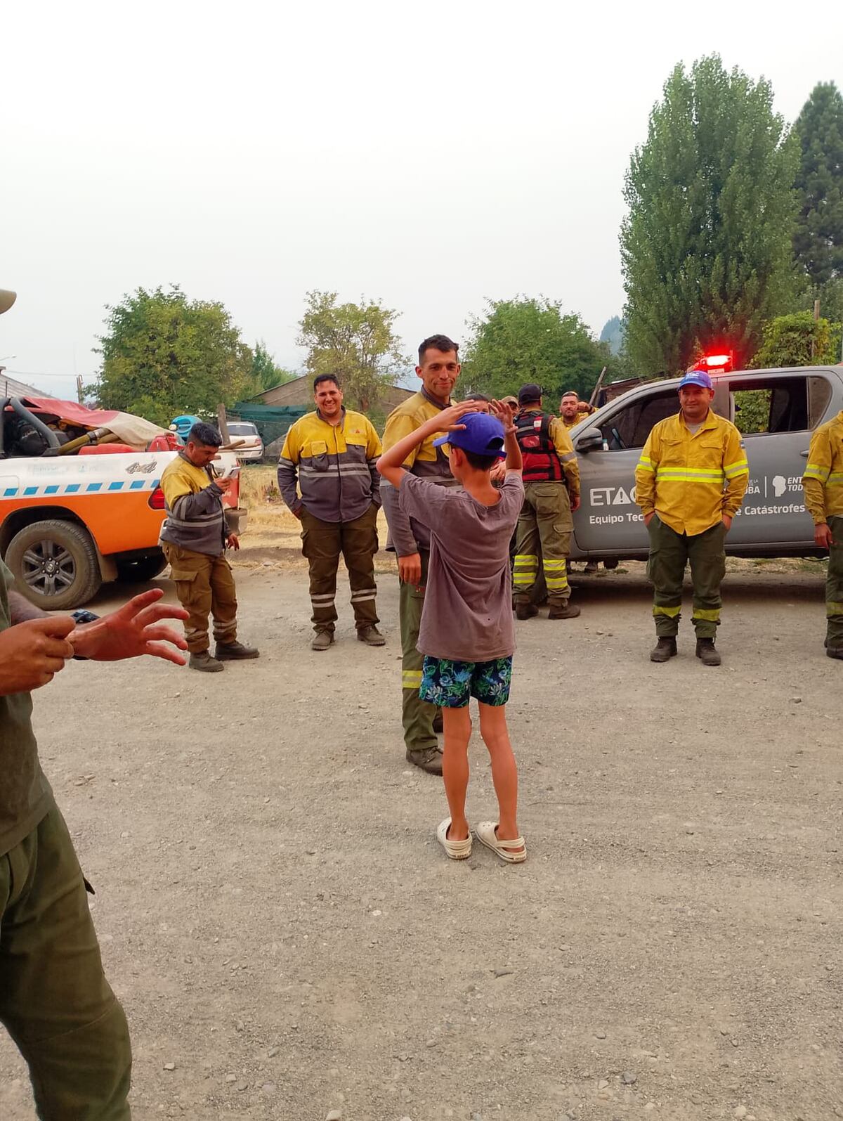 El niño en medio del grupo de bomberos cordobeses.