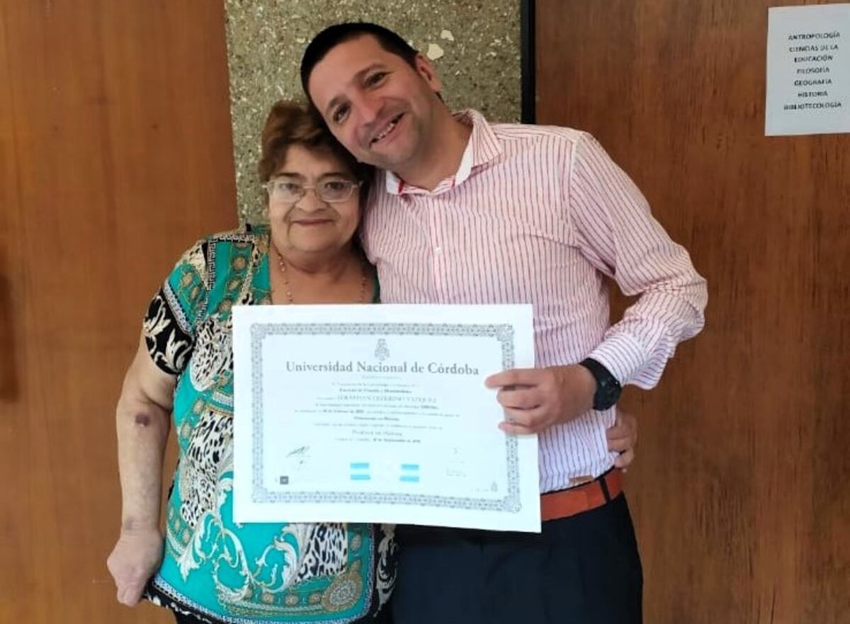 Sebastián con su madre, y con el título de la UNC recién obtenido en la mano