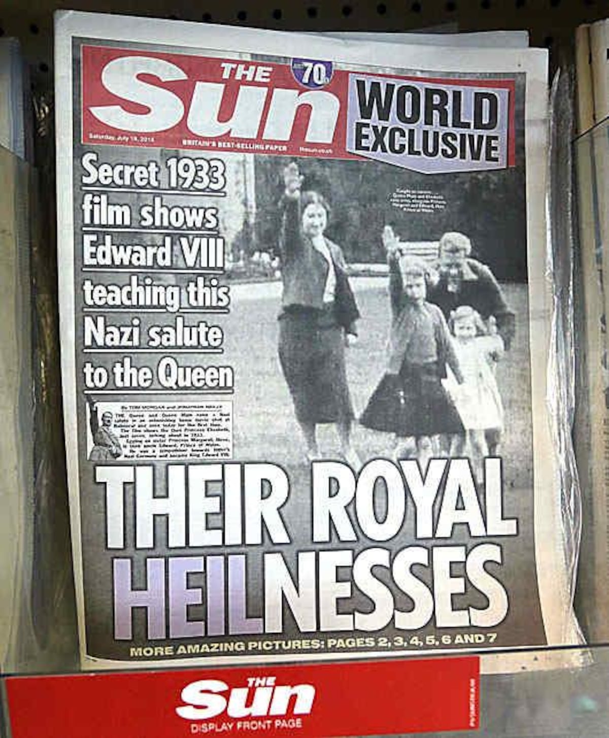 Reina en apuros. Diario con una foto de la reina Isabel de niña haciendo el saludo nazi, en una tienda, de Londres, en julio de 2015. El Palacio de Buckingham ha expresado su decepción con el periódico sensacionalista The Sun por la publicación de imágenes de una joven reina Isabel II  realizando el saludo nazi junto con su familia en 1933, año en que Adolf Hitler llegó al poder. El palacio tomó la inusual decisión de hacer comentarios sobre el informe del diario que muestra a la reina, de 7 años de edad, en la casa de la familia en Balmoral, rodeada por su tío, madre y hermana. Las imágenes granuladas muestran también a la madre de Elizabeth haciendo el saludo.