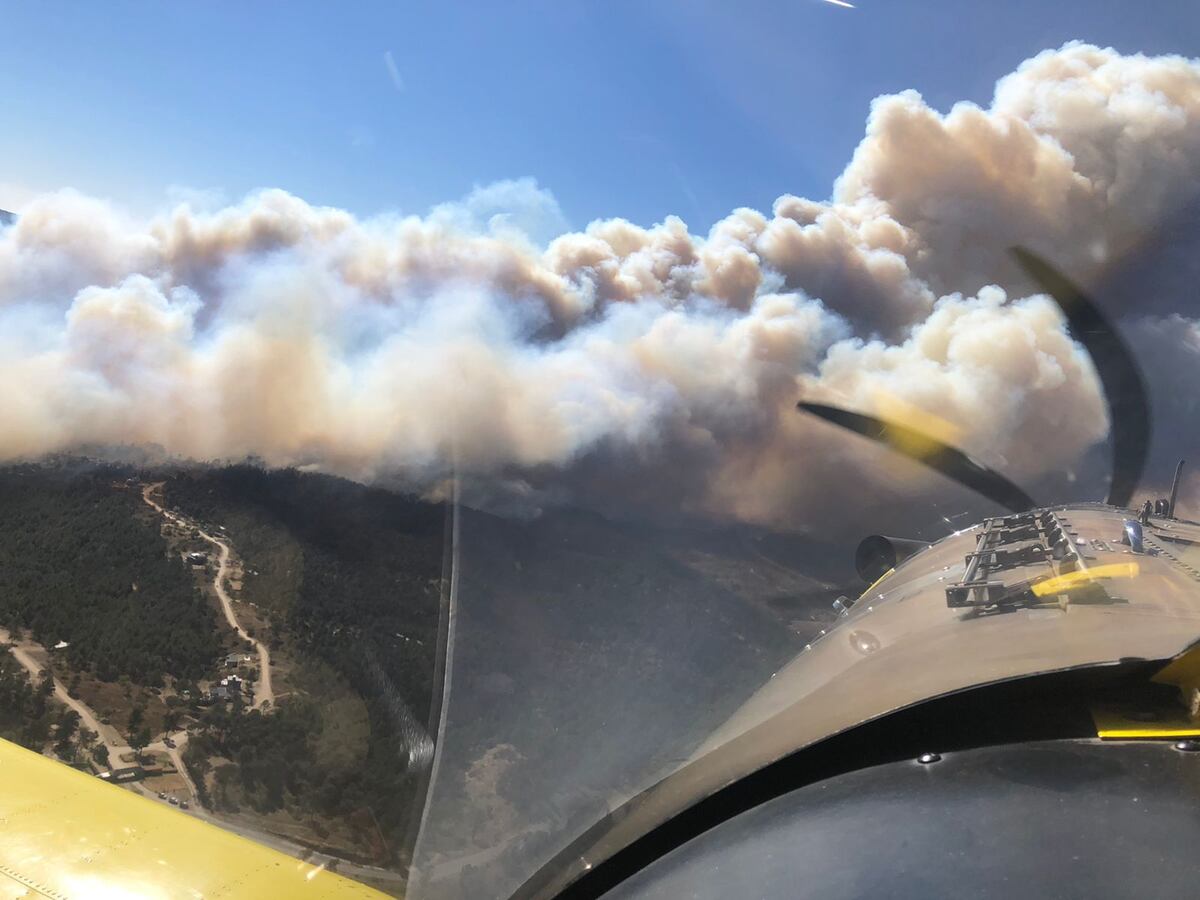 La vista desde el puesto del piloto de un avión hidrante. Abajo, el foco de este miércoles en Potrero de Garay (Gentileza PPMF)