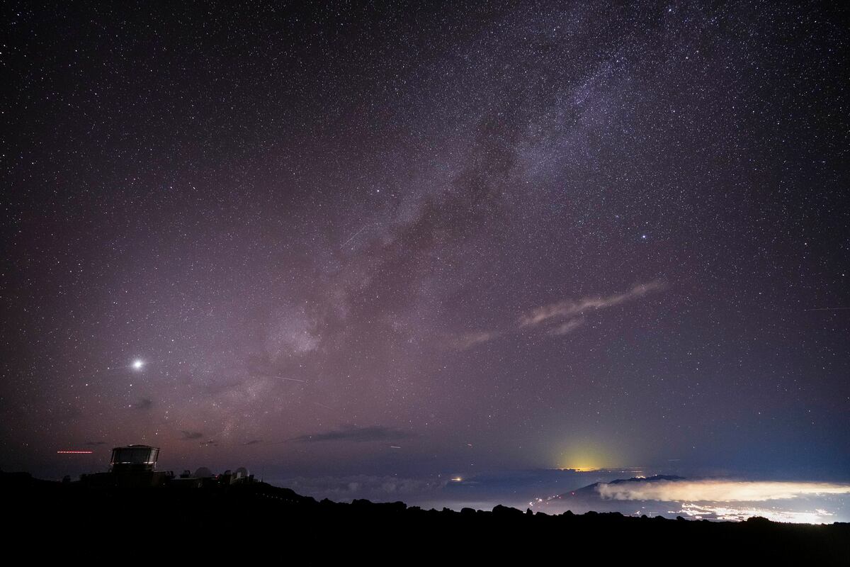 La Vía Láctea sobre el Observatorio Haleakala Observatory y las luces de Kahului, en el Parque Nacional Haleakala cerca de Kula, Hawai, el 23 de noviembre del 2024. (AP foto/Lindsey Wasson)