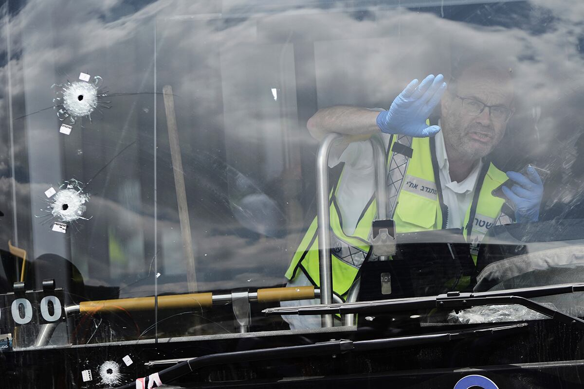 La policía israelí y los equipos de rescate inspeccionan el lugar de un tiroteo perpetrado por dos hombres armados palestinos, en el que varias personas murieron y otras resultaron heridas en una parada de autobús en Jerusalén, el lunes 8 de septiembre de 2025. (Foto AP/Mahmoud Illean)