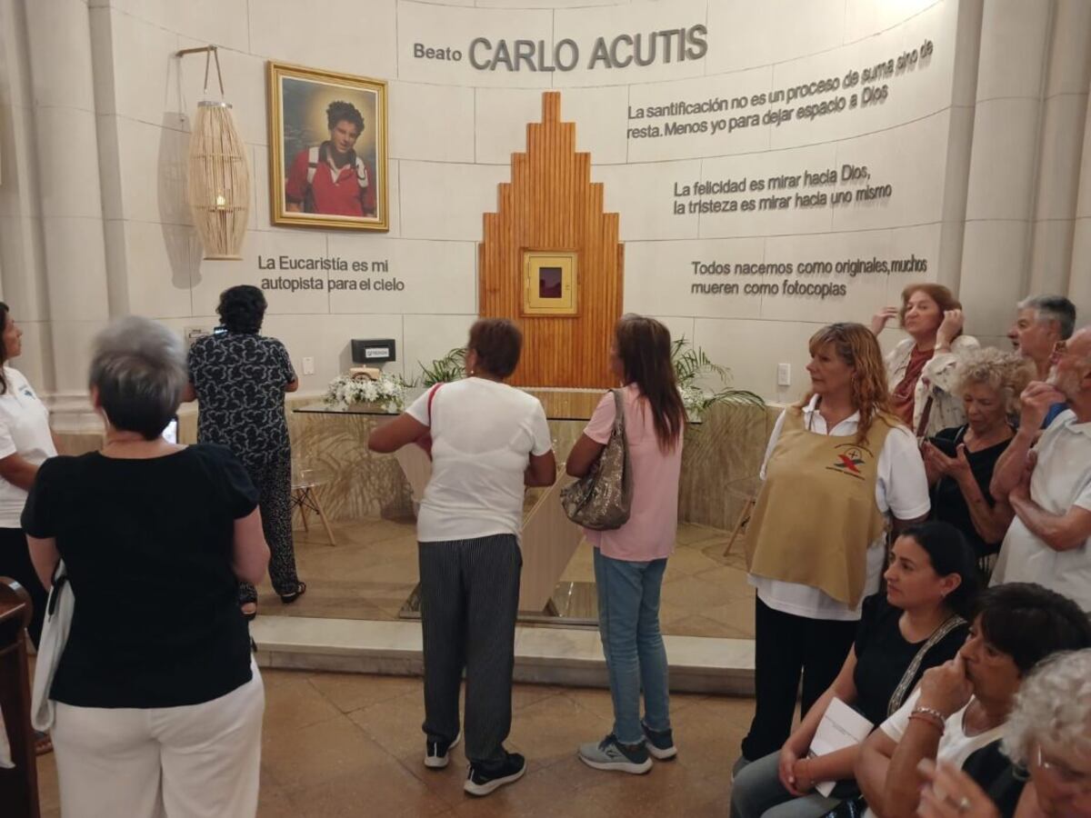 Peregrinos frente al altar en honor a Acutis en el templo de La Falda.