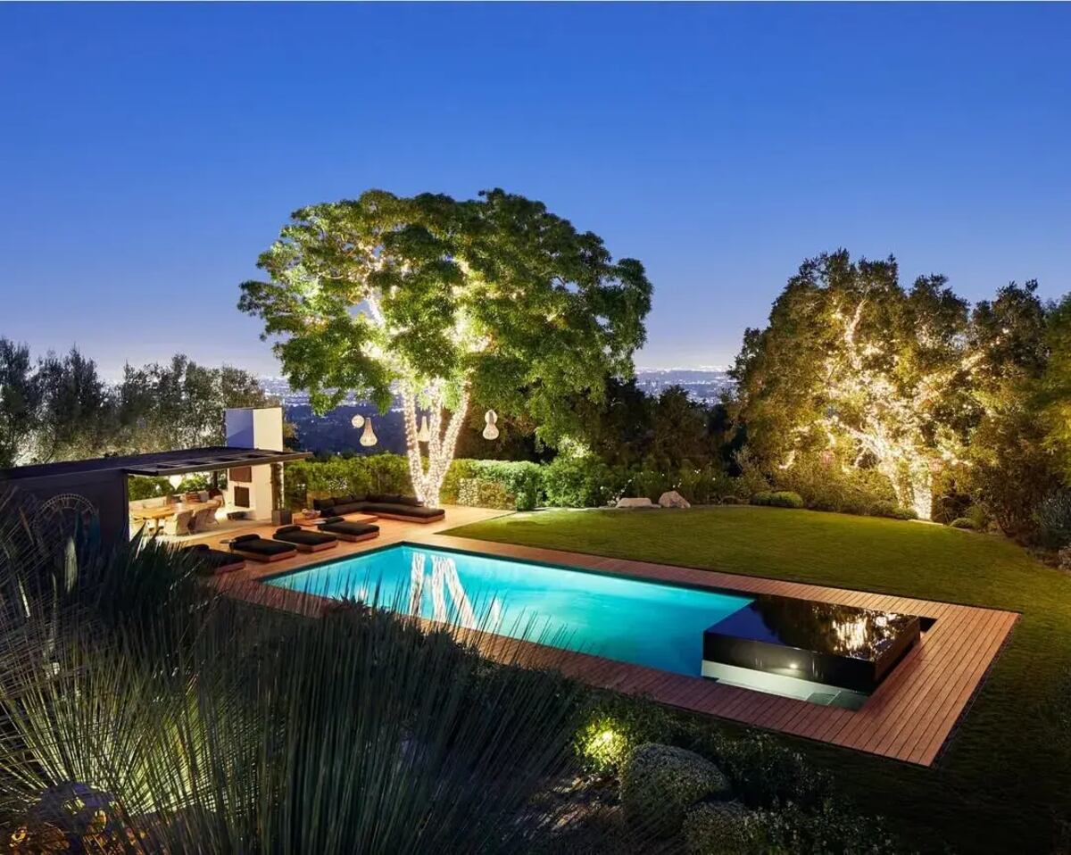 El patio con jardín y enorme pileta iluminada de Jennifer Aniston.