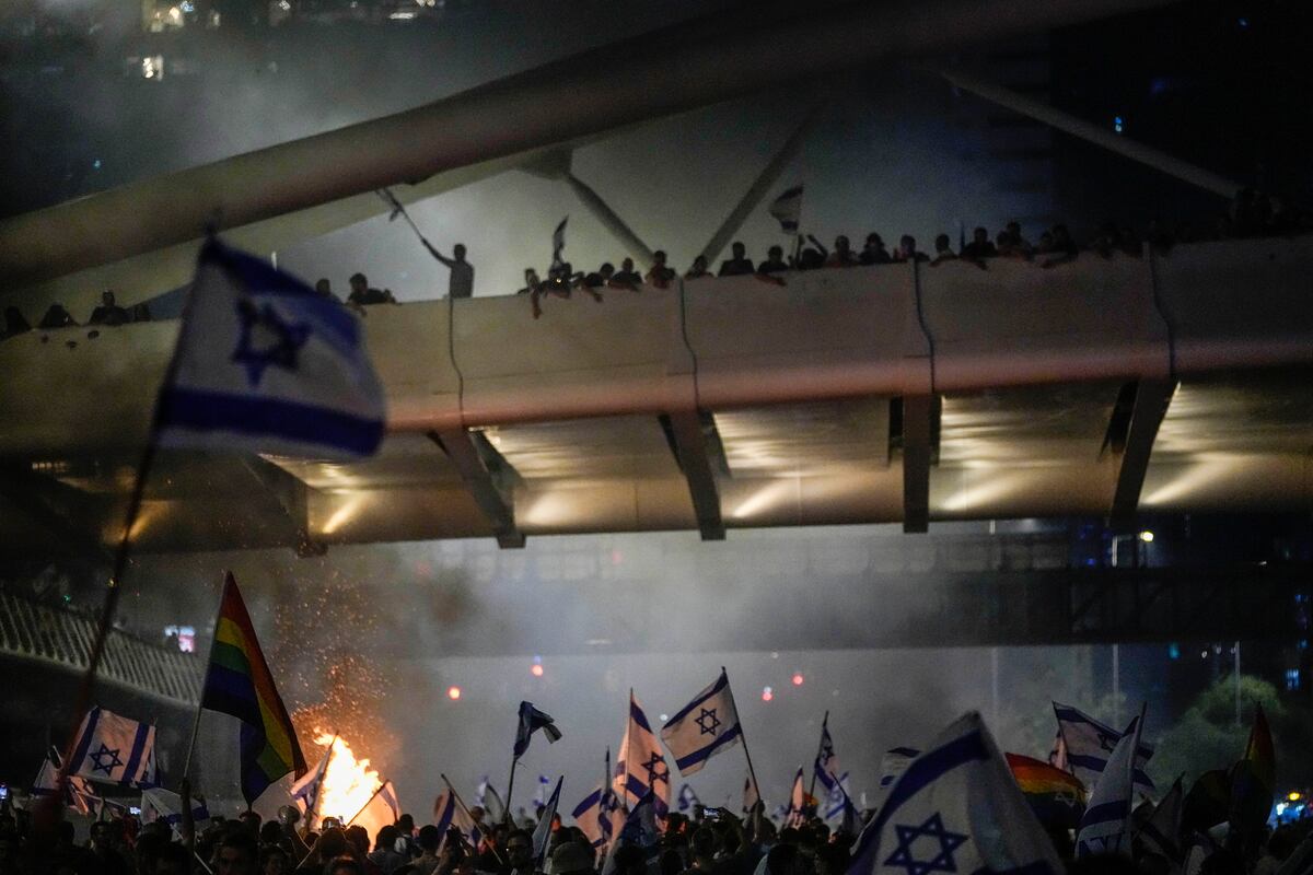 Una hoguera arde mientras israelíes ocupan la autopista Ayalon para protestar contra la propuesta de reforma del sistema judicial del gobierno del primer ministro, Benjamin Netanyahu, en Tel Aviv, el 20 de julio de 2023. (AP Foto/Ariel Schalit)