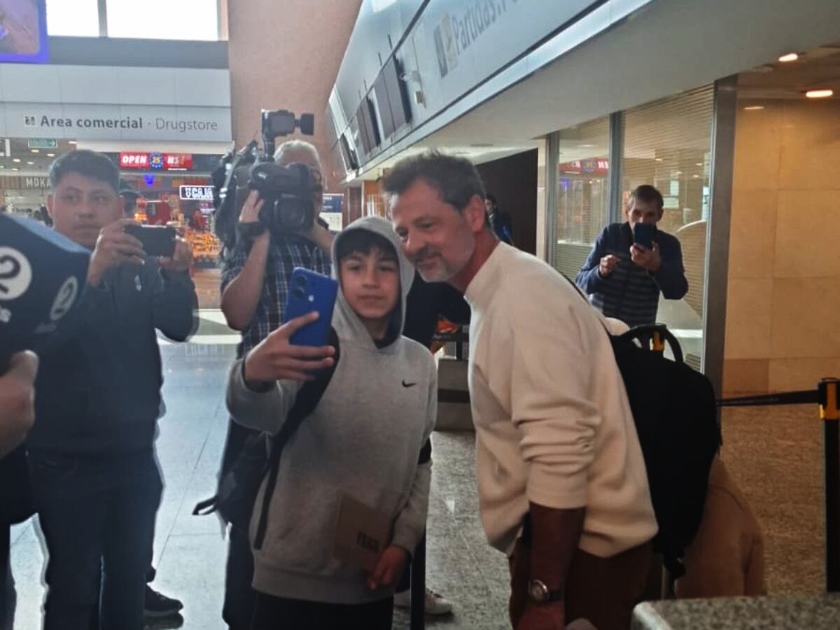 Diego Cocca se toma la foto con un niño en el Aeropuerto.