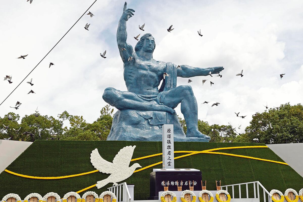 Palomas sobrevuelan la Estatua de la Paz durante una ceremonia para conmemorar el 77.° aniversario del bombardeo atómico de EE. UU. en el Parque de la Paz en Nagasaki, sur de Japón, el martes 9 de agosto de 2022. (AP)