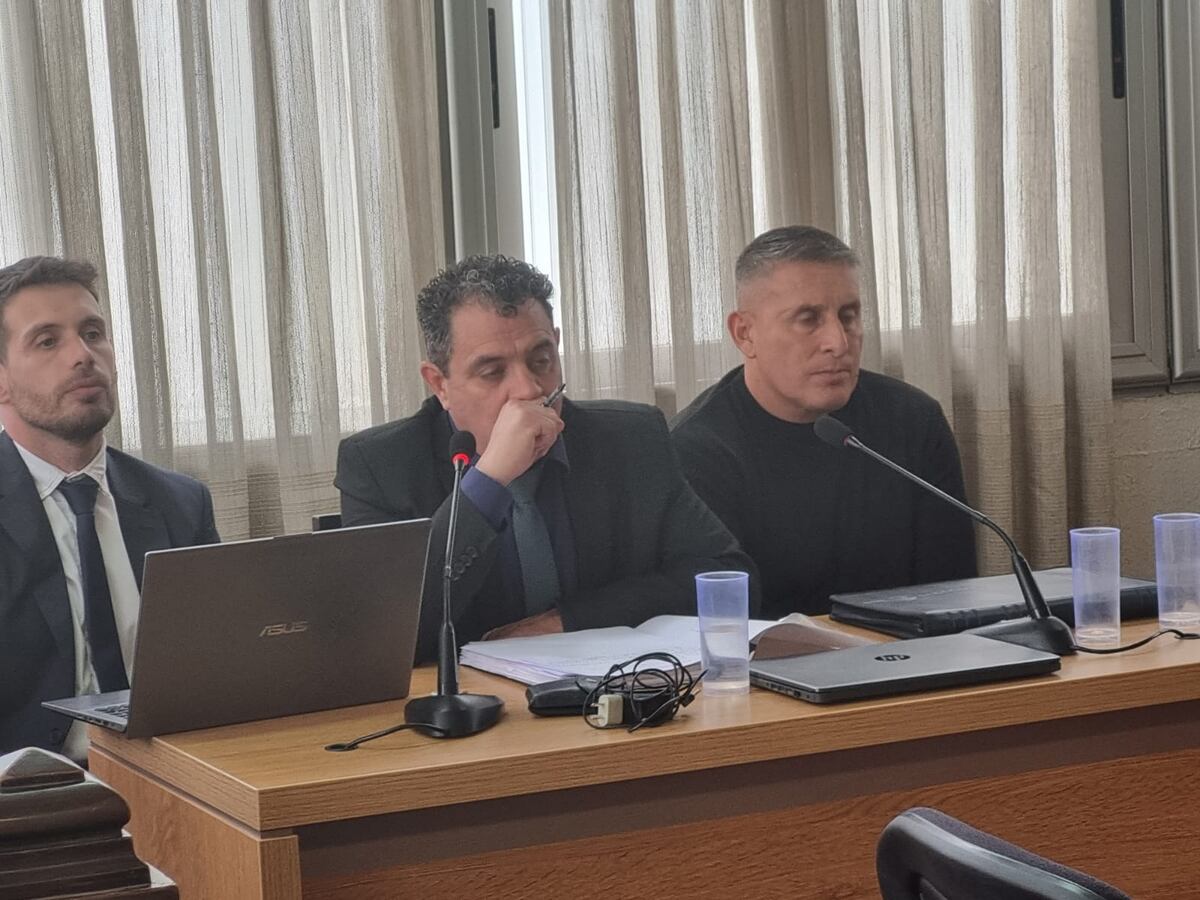 El policía acusado, junto a su defensa en el juicio