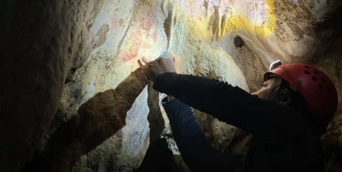 El tenue contorno de la plantilla de la mano detallada en el nuevo estudio se puede ver aquí entre otras pinturas rupestres. Universidad Griffith