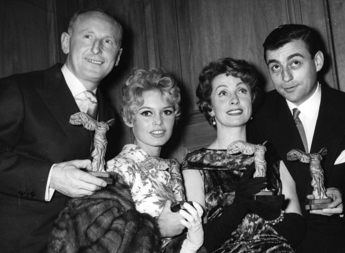 André Bourvil, Brigitte Bardot, Danielle Darrieux y Fraçois Périer, posan para una foto con sus estatuillas de premios cinematográficos franceses, en París, Francia, el 3 de diciembre de 1963. (AP/ Jacques Marqueton, archivo)