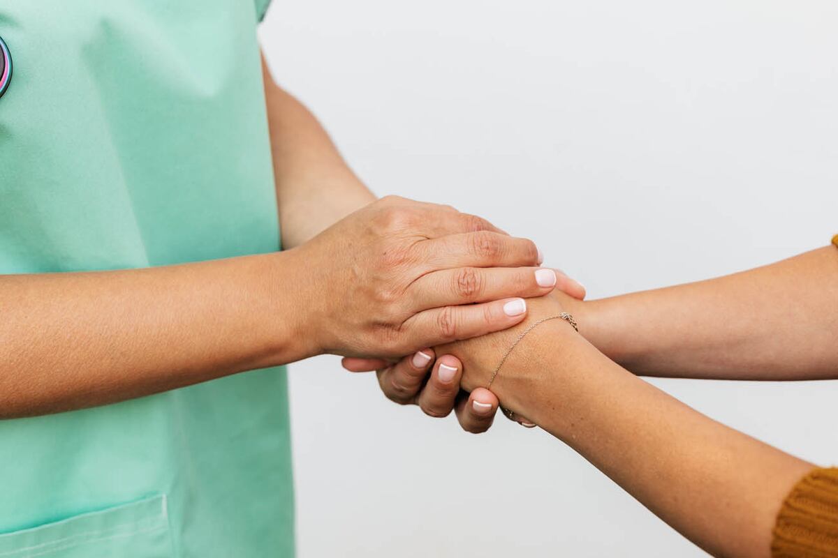 Médico sosteniendo las manos de paciente. Fotos: Pexels.