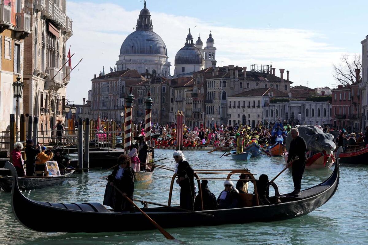 Personas disfrazadas navegan en botes durante el tradicional desfile de remo, parte del histórico Carnaval de Venecia, en Venecia (Foto AP/Antonio Calanni)