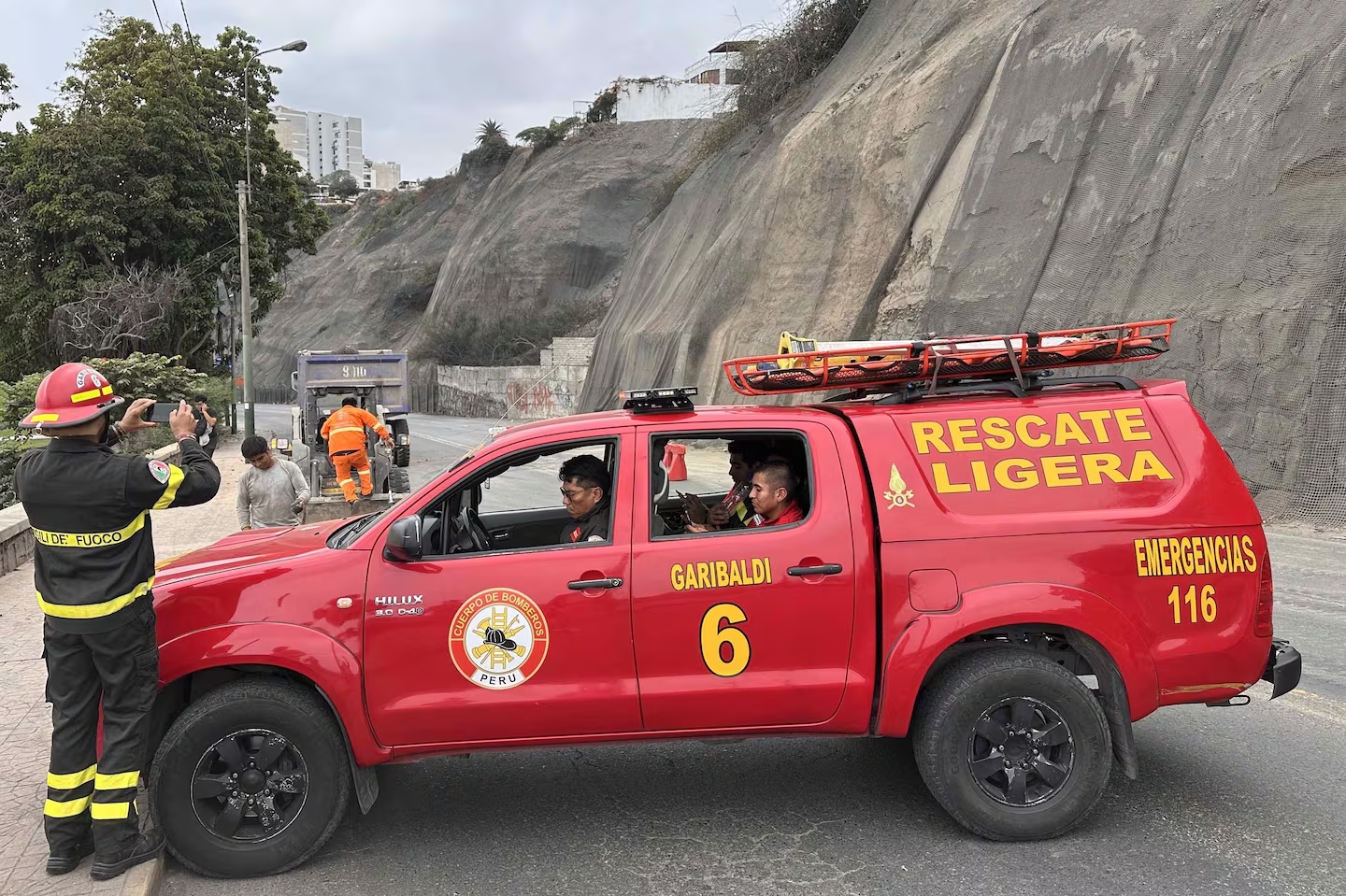 Integrantes de equipos de rescate cierran la avenida Costa Verde por derrumbes en el acantilado, producto del sismo ocurrido este domingo, en Lima (Foto: EFE)