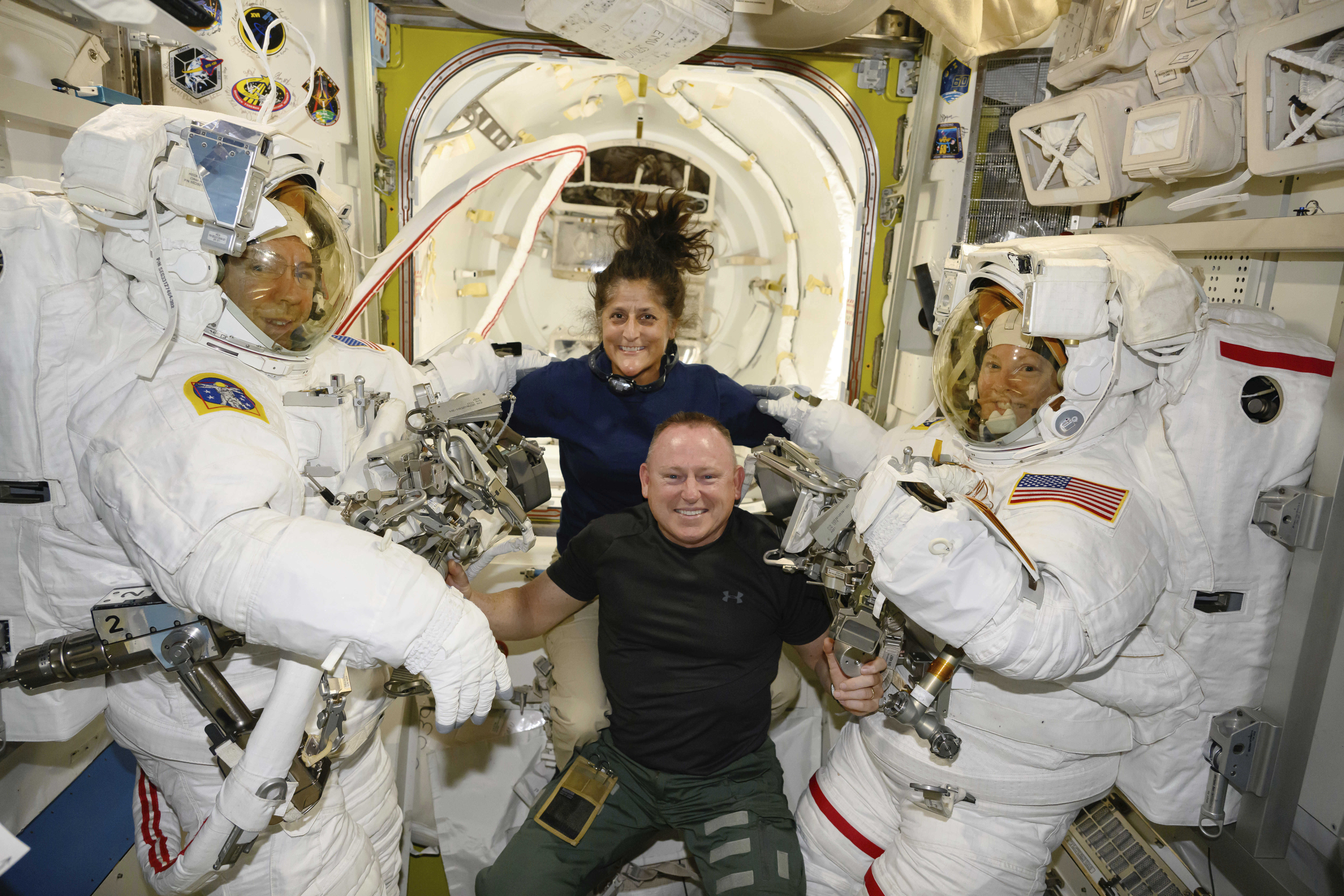 En esta foto facilitada por la NASA, los astronautas del lanzamiento de prueba de Boeing, Suni Williams y Butch Wilmore, en el centro, posan con los ingenieros de vuelo de la expedición 71, Mike Barratt, a la izquierda, y Tracy Dyson, ambos astronautas de la NASA, en sus trajes espaciales a bordo de la esclusa Quest de la Estación Espacial Internacional, el 24 de junio de 2024. (NASA vía AP)