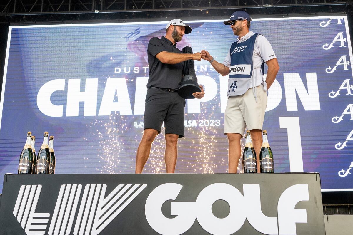 En foto del 14 de mayo del 2023, el campeón individual Dustin Johnson y su caddie Austin Johnson celebra en el podio durante la ceremonia de trofeo en el torneo LIV Golf Tulsa e Cedar Ridge Country Club. (Amy Kontras/LIV Golf via AP)