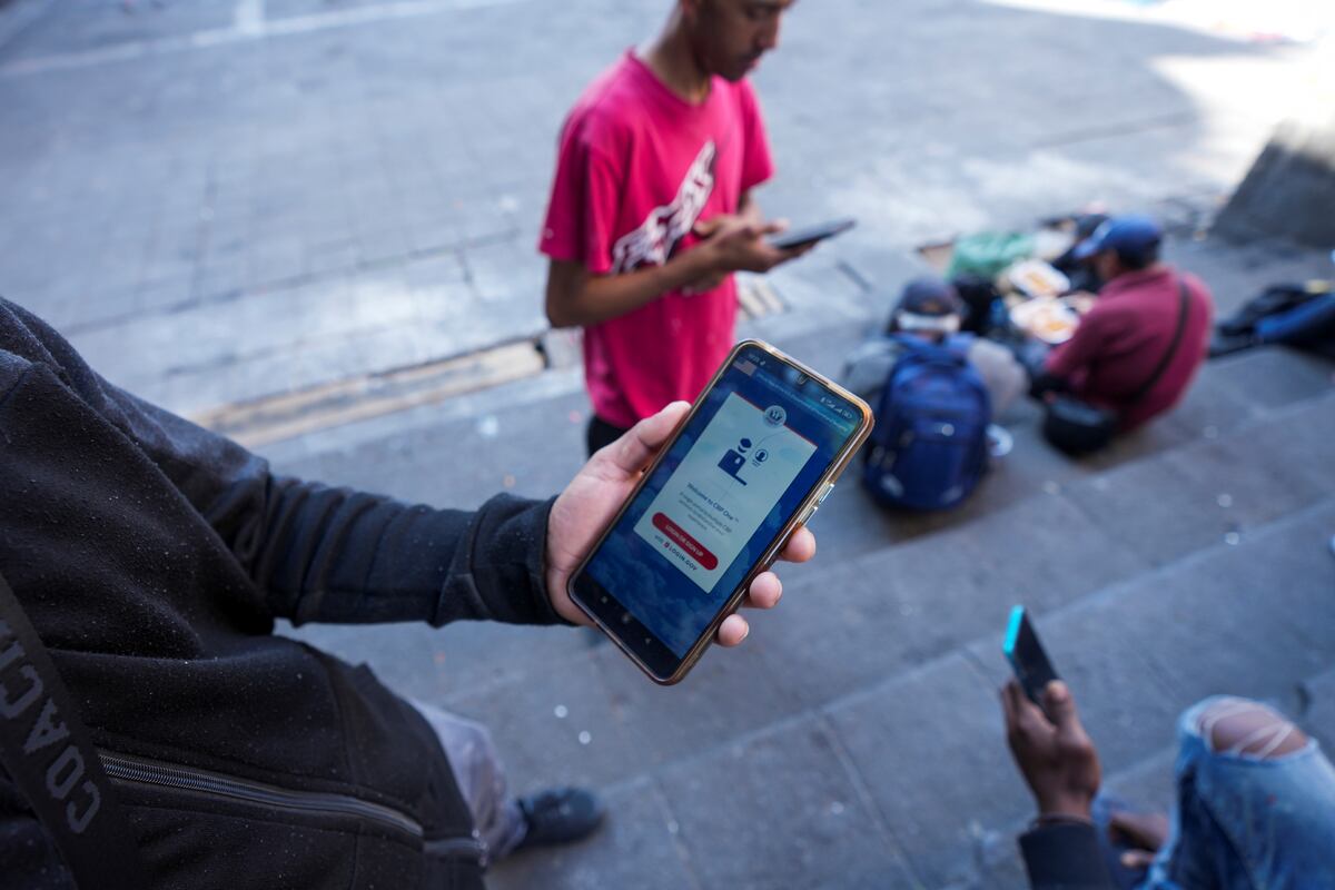 Venezuelan migrant Yender Romero shows the U.S. Customs and Border Protection (CBP) One app on his cell phone, which he said he used to apply for asylum in the U.S. and is waiting on an answer, at a migrant tent camp outside La Soledad church in Mexico City, Monday, Jan. 20, 2025, the inauguration day of U.S. President Donald Trump. (AP Photo/Fernando Llano)