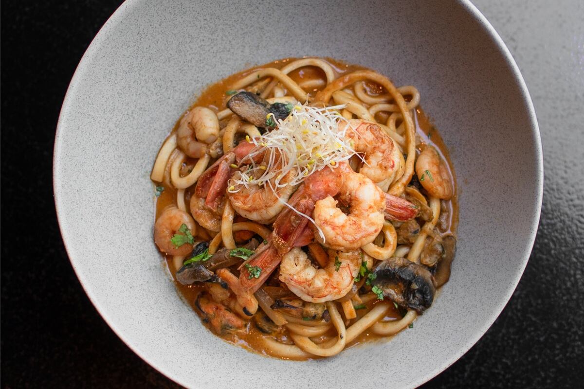 Wok de langostinos y fideos udon: una de las opciones calientes que combinan tradición oriental y creatividad contemporánea.