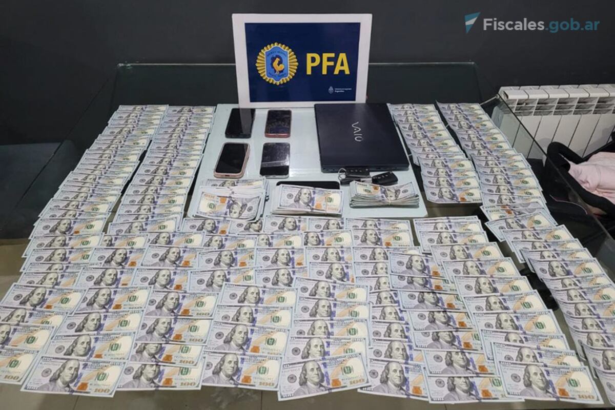 Celulares, una computadora y dólares secuestrados en uno de los allanamientos. (Policía Federal/Fiscales.gob.ar)
