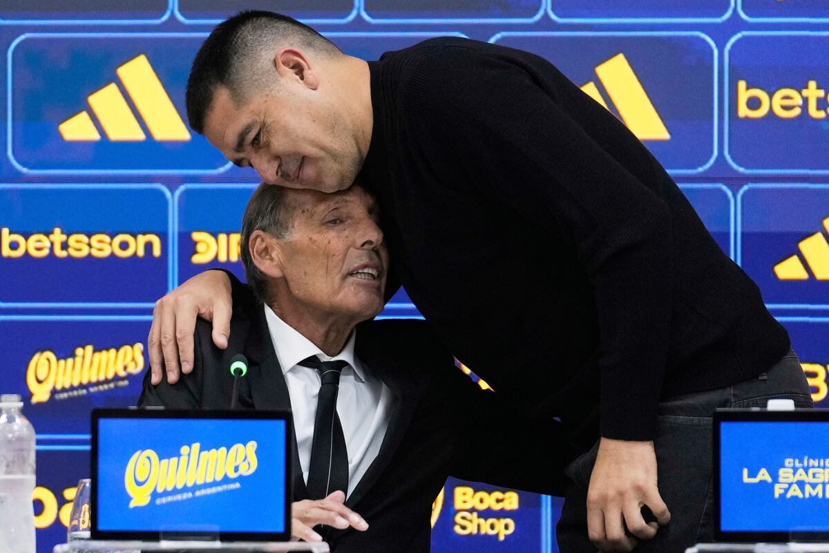 El presidente de Boca Juniors, Juan Román Riquelme, a la derecha, abraza al nuevo entrenador Miguel Ángel Russo durante una conferencia de prensa en Buenos Aires, Argentina, lunes 2 junio, 2025. (AP Foto/Gustavo Garello)