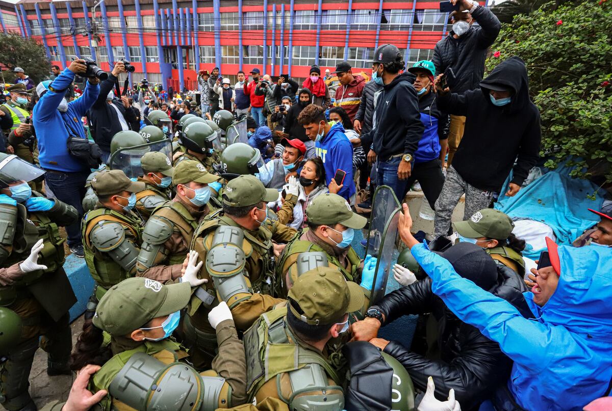 Oquique. Migrantes venezolanos se enfrentan a la policía mientras son desalojados de su campamento. (AP)