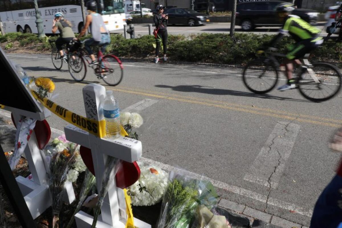 TRI06 NUEVA YORK (ESTADOS UNIDOS), 03/11/2017\u002E- Personas observan el pequeño homenaje con flores y una camiseta argentina en una barricada policial a lo largo del carril bici en el que se produjo el atentado del pasado 31 de octubre en Nueva York, Estados Unidos, hoy, 3 de noviembre de 2017\u002E El atentado se produjo el martes en el suroeste de la isla de Manhattan, cuando un inmigrante uzbeco identificado como Sayfullo Saipov, de 29 años, arrolló con su vehículo a varias personas que se encontraban en el lugar\u002E EFE/ANDREW GOMBERT