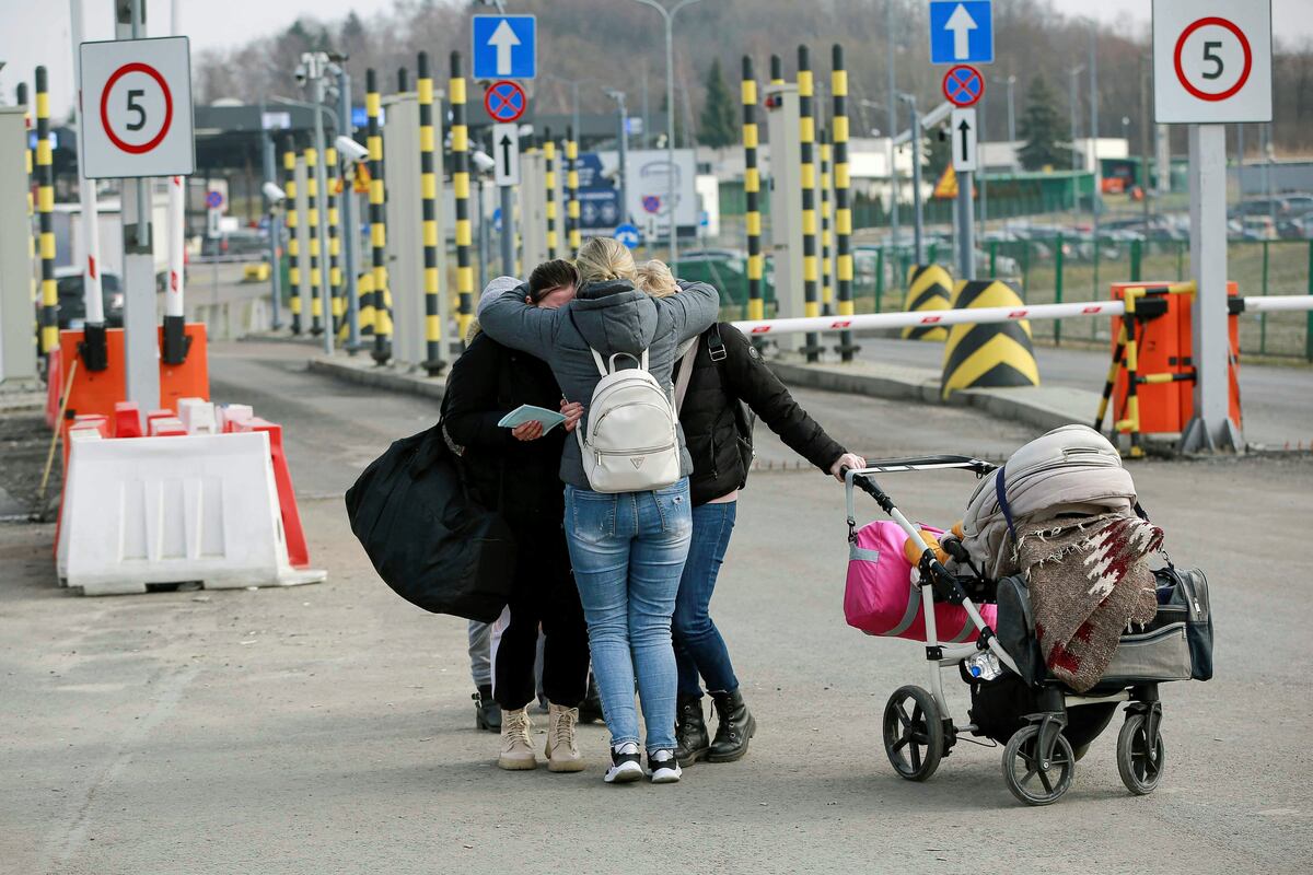 Una familia ucraniana se abraza antes de emprender la travesía en busca de un refugio fuera del país asediado. (AP)