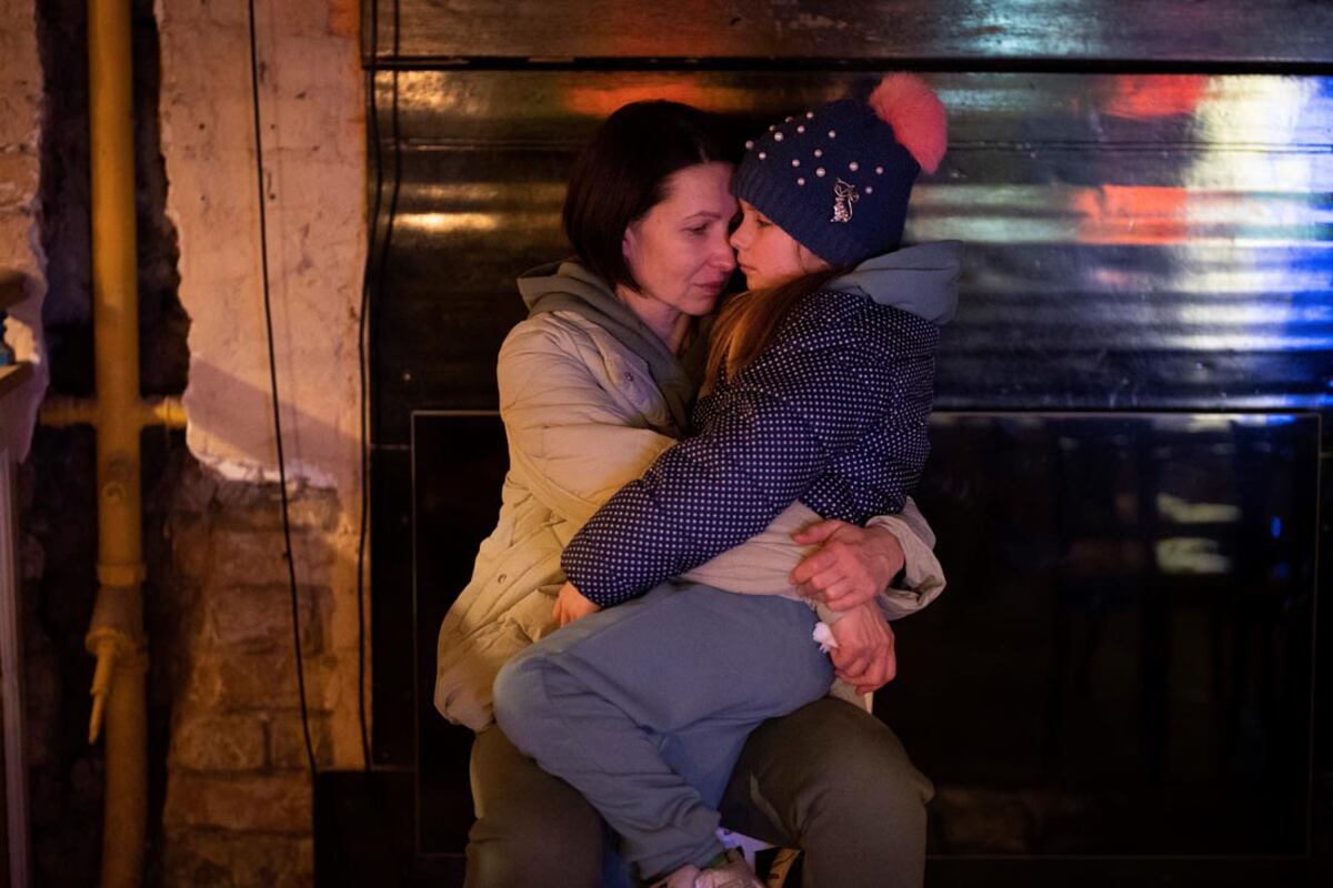 Una mujer sostiene a su hija sentada en un sótano utilizado como refugio antiaéreo en Kiev, Ucrania. (AP)