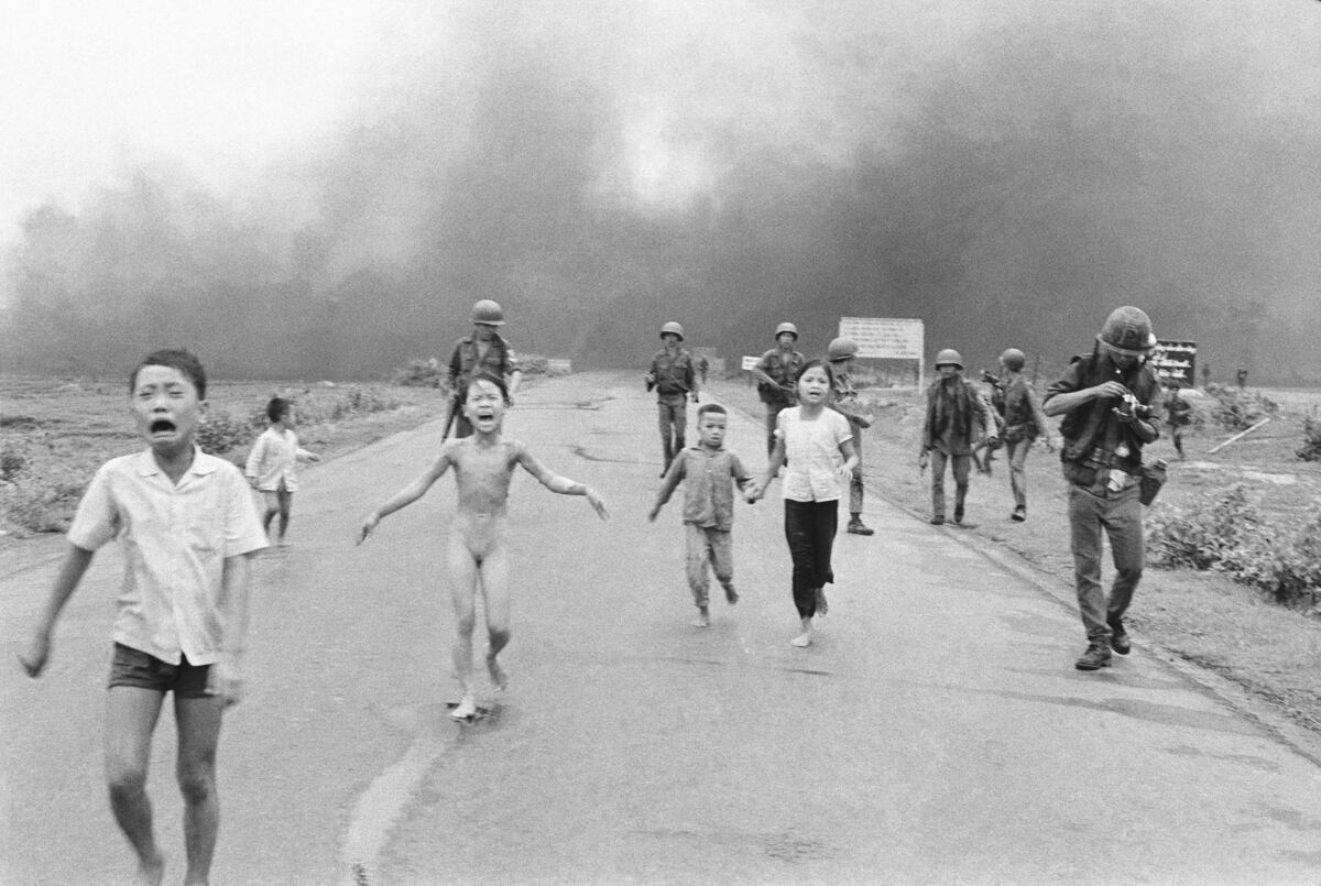 Las fuerzas de Vietnam del Sur siguen a niños aterrorizados, incluida Kim Phuc, de 9 años, en el centro, mientras corren por la Ruta 1 cerca de Trang Bang después de un ataque aéreo con napalm contra presuntos escondites del Viet Cong, el 8 de junio de 1972. (Foto AP/Nick Ut, archivo)
