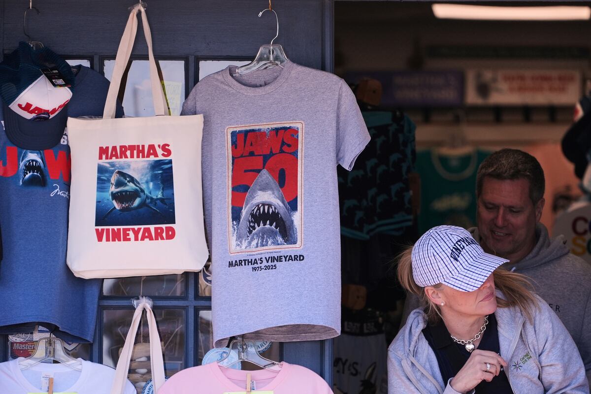 Una persona pasa junto a algunos artículos de la película "Tiburón" en la tienda de regalos Sea Chest, el lunes 12 de mayo de 2025, en Vineyard Haven, Massachusetts, en Martha's Vineyard Island, donde la película se filmó hace 50 años. (AP Foto/Charles Krupa)